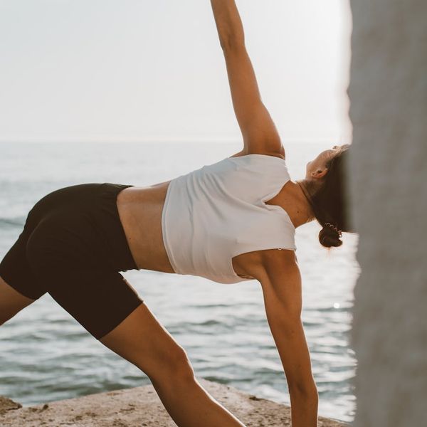 Person feeling energetic and stretching outdoors at sunrise.